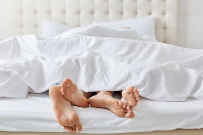 horizontal-shot-feet-couple-white-bedclothes-bed-bedroom_176532-7942.jpg